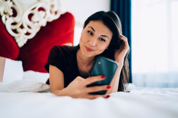 Attractive hipster girl reading received sms message on cellphone technology