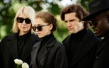 People dressed in black at outdoor funeral