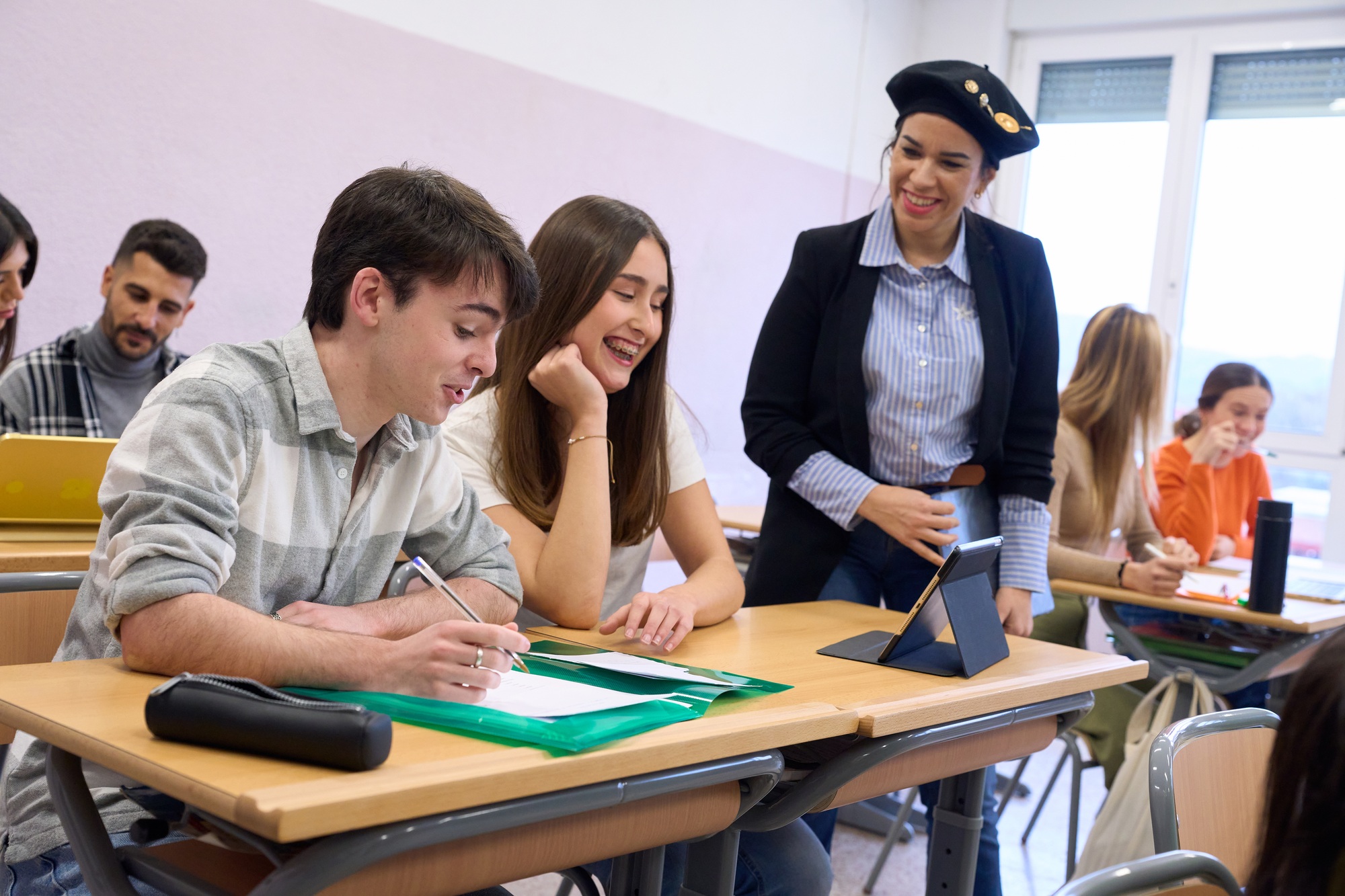 Teacher helping students studying and learning in classroom at high school