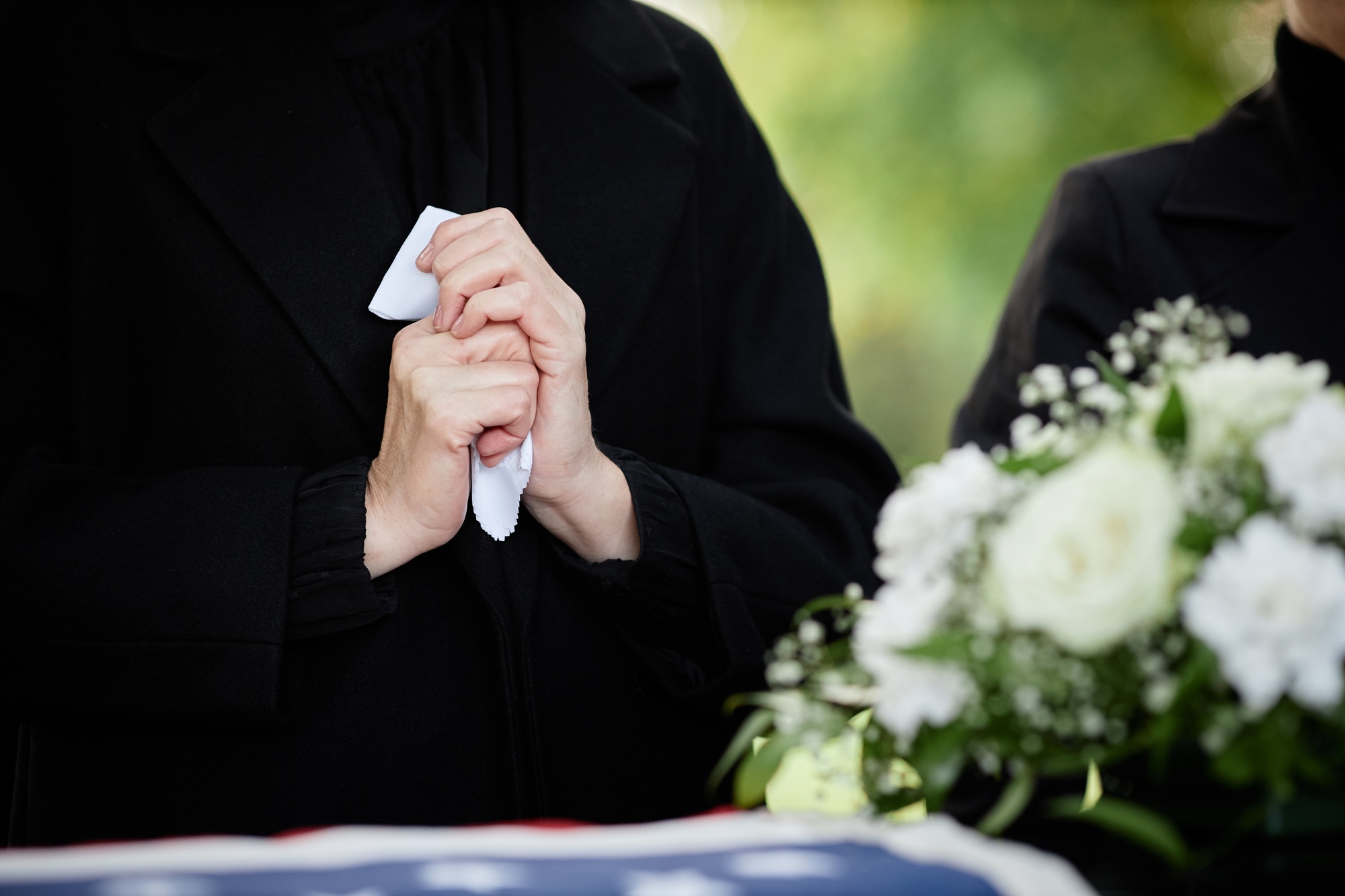 Woman crying at outdoor funeral ceremony
