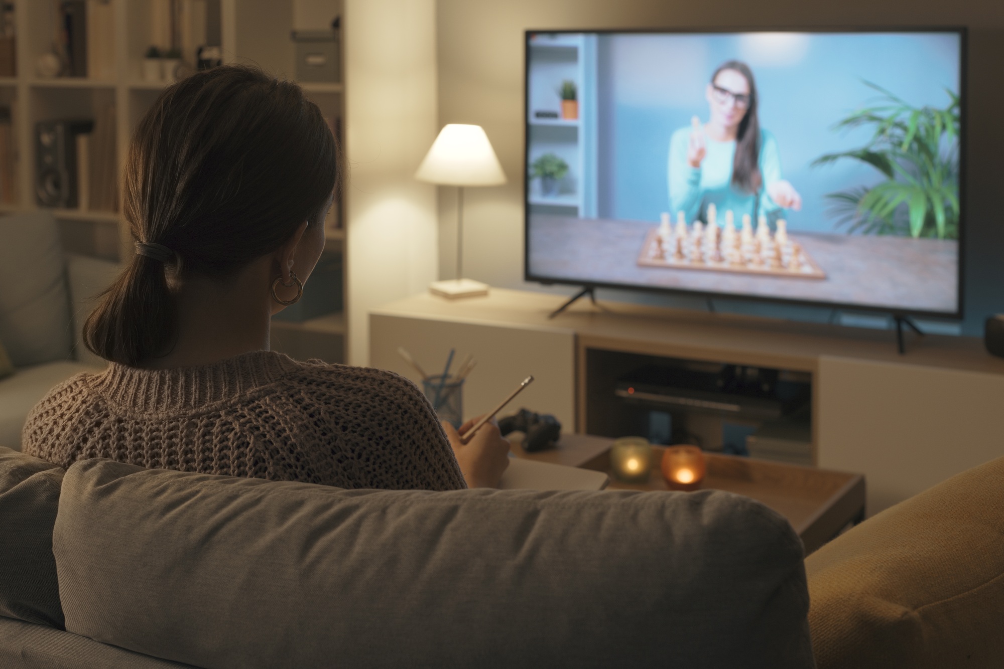 Woman learning chess on TV