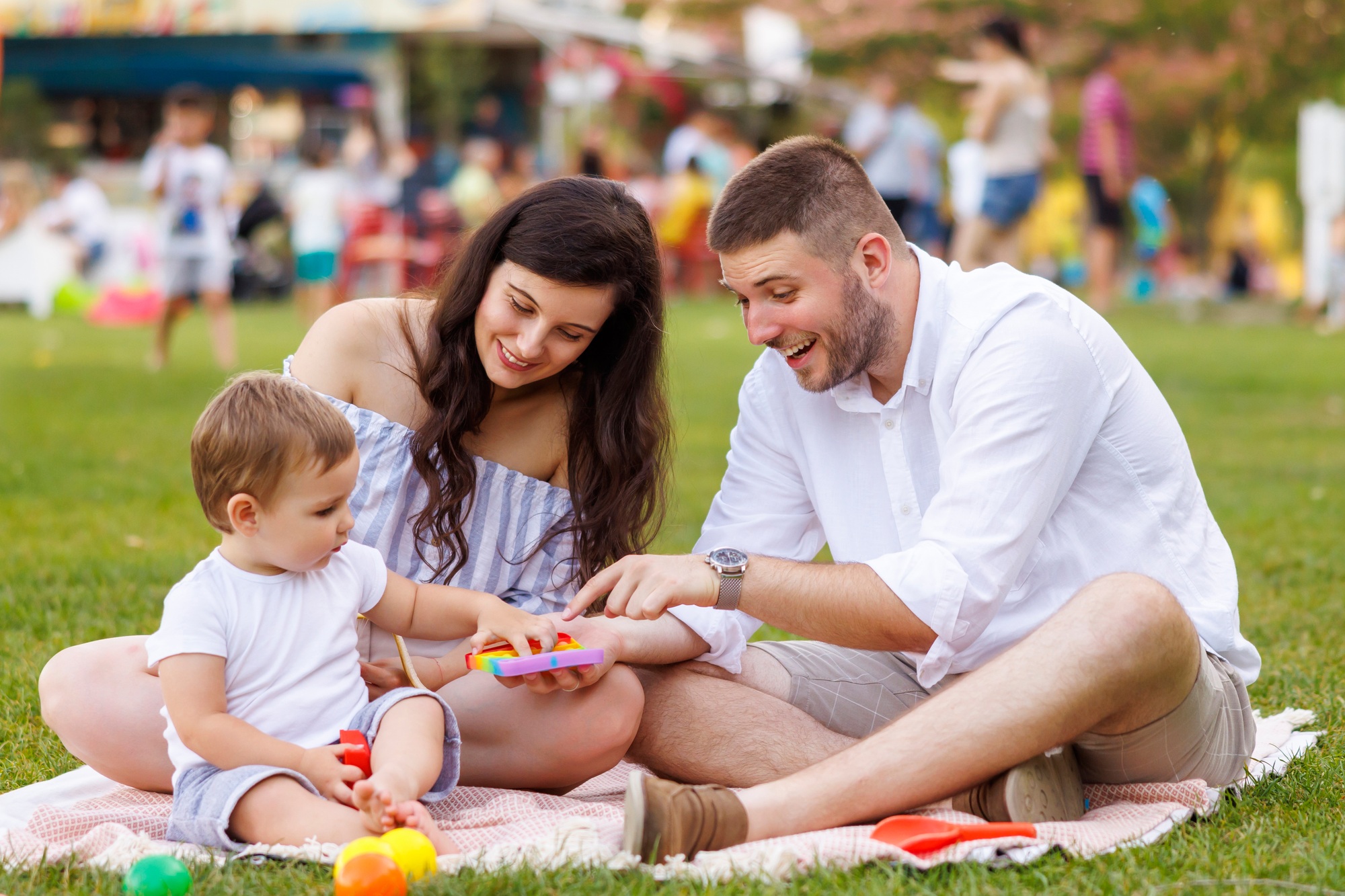 Young parents having fun on picnic with their child